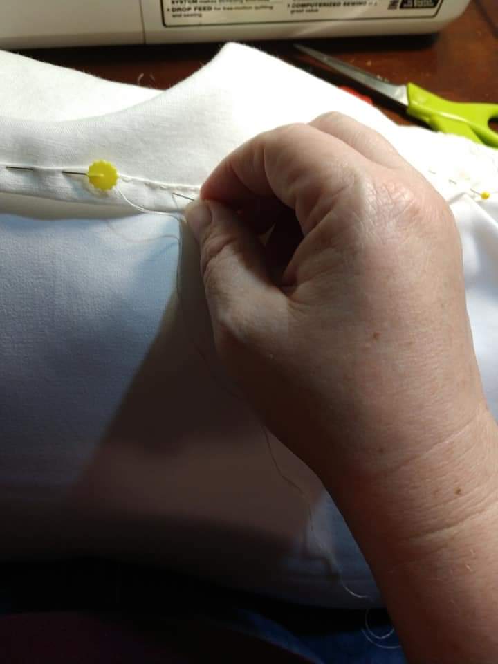 Hand stitching hem using the pillow to anchor the work